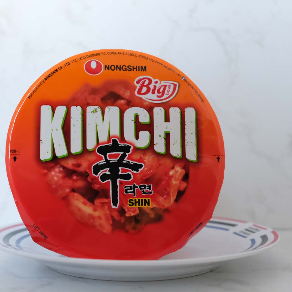 Bowl Noodle Kimchi di Nongshim con sfondo marmo e piatto di Scaffale Coreano