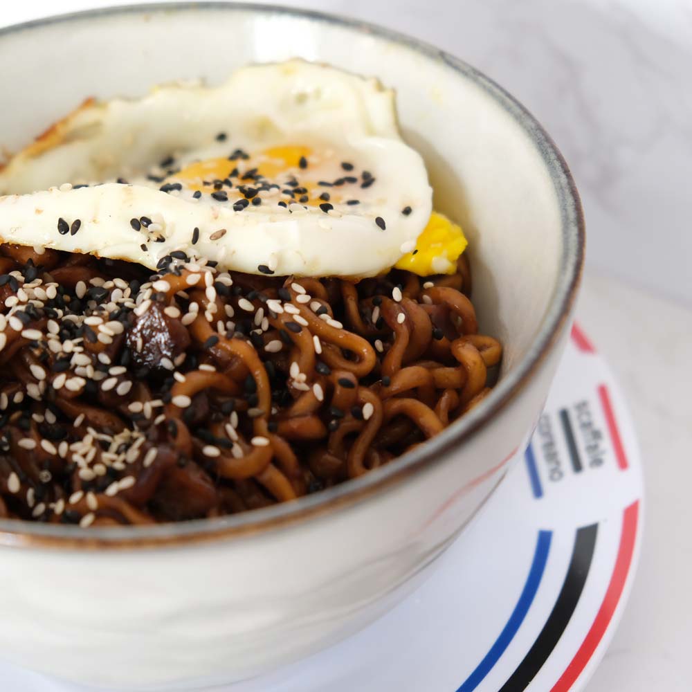 Piatto fumante di Chapagetti Chajangmyun di Nongshim con sfondo marmo e piatto di Scaffale Coreano