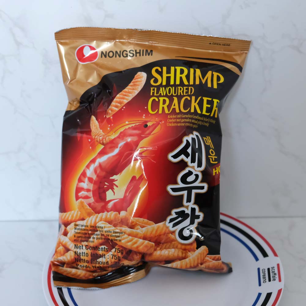 Cracker ai gamberetti piccanti seukkang di Nongshim con sfondo marmo e piatto di Scaffale Coreano