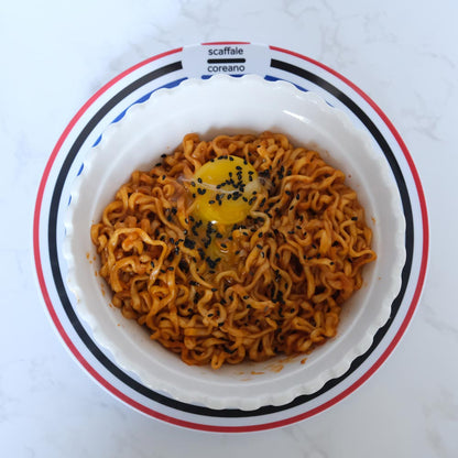 Piatto fumante di Hot Chicken Cheese Buldak Ramen di SamYang con sfondo marmo e piatto di Scaffale Coreano dall'alto