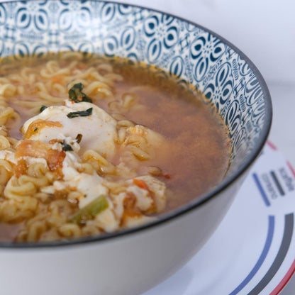 Piatto fumante di Kimchi Shin Ramyun di Nongshim con sfondo marmo e piatto di Scaffale Coreano