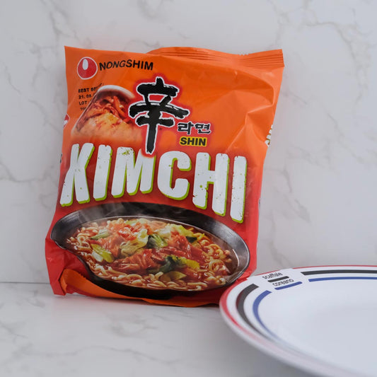 Kimchi Shin Ramyun di Nongshim con sfondo marmo e piatto di Scaffale Coreano