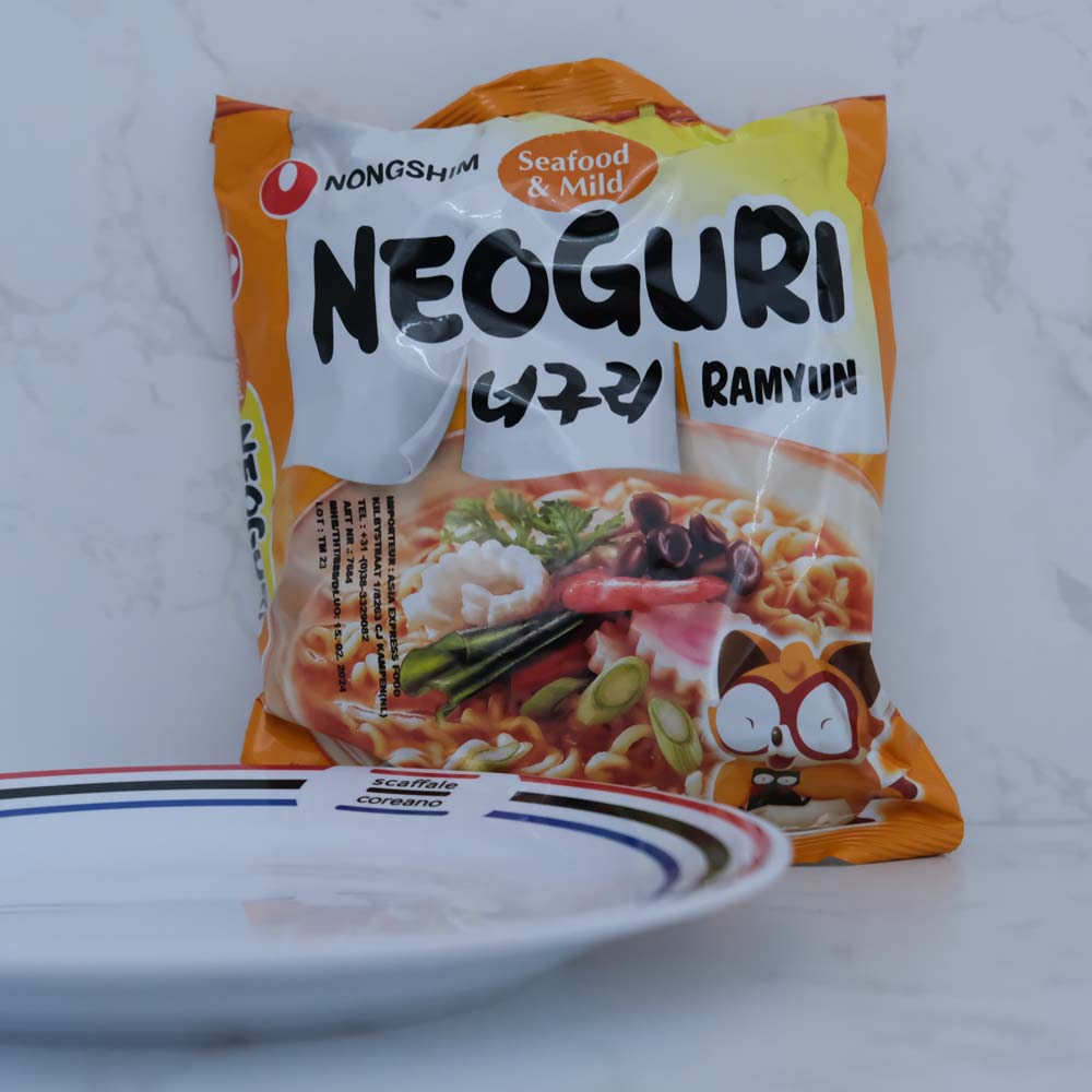 Neoguri Ramyun Mild di Nongshim con sfondo marmo e piatto di Scaffale Coreano