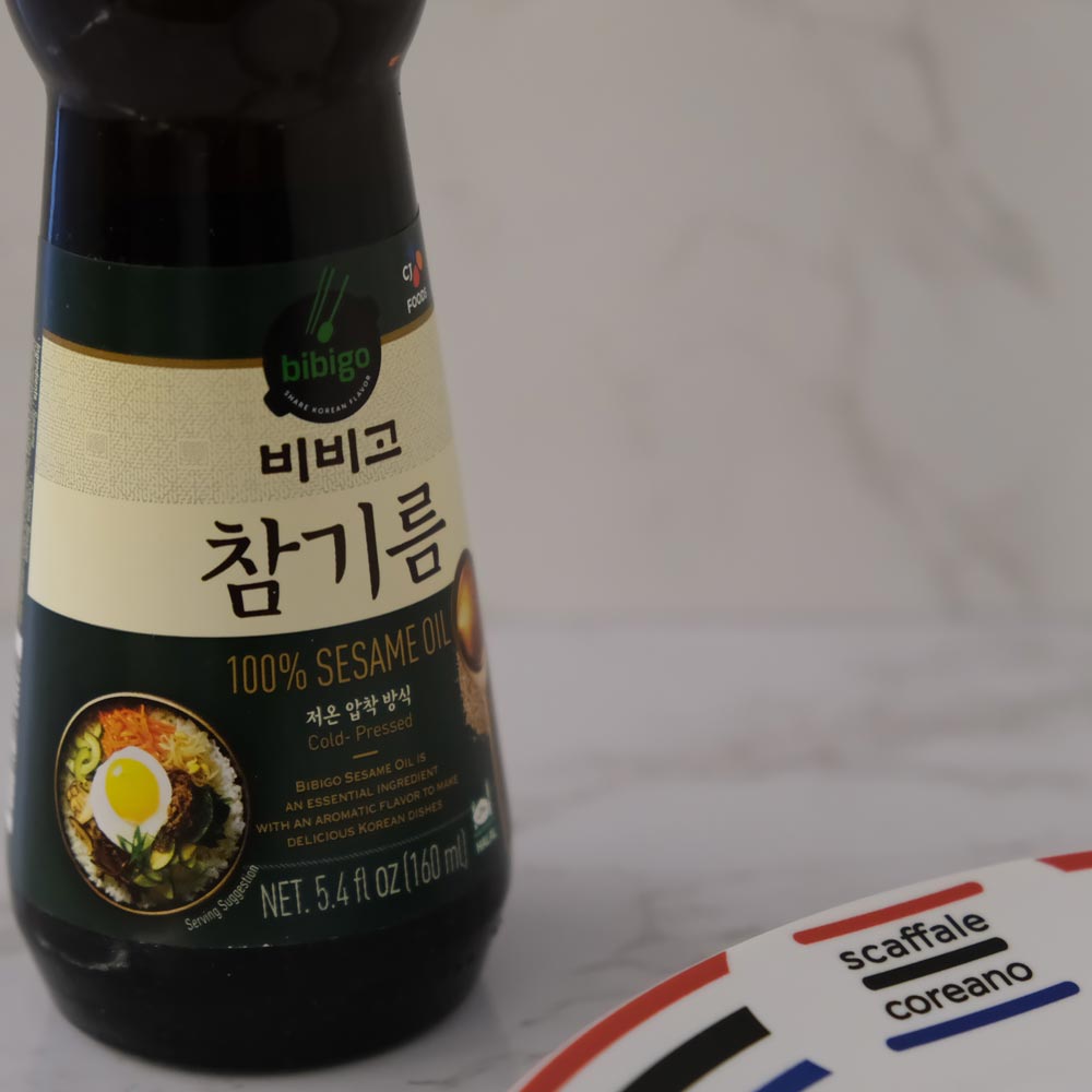 Olio di Sesamo Bibigo CJ con sfondo marmo e piatto di Scaffale Coreano
