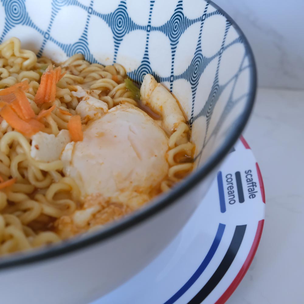 Piatto fumante di Shin Ramyun di Nongshim con sfondo marmo e piatto di Scaffale Coreano