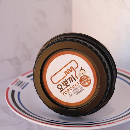 Yopokki Aglio Teriyaki Cup con sfondo marmo e piatto di Scaffale Coreano