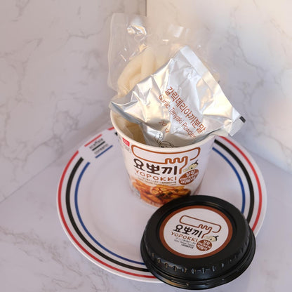 Yopokki Aglio Teriyaki Cup con sfondo marmo e piatto di Scaffale Coreano