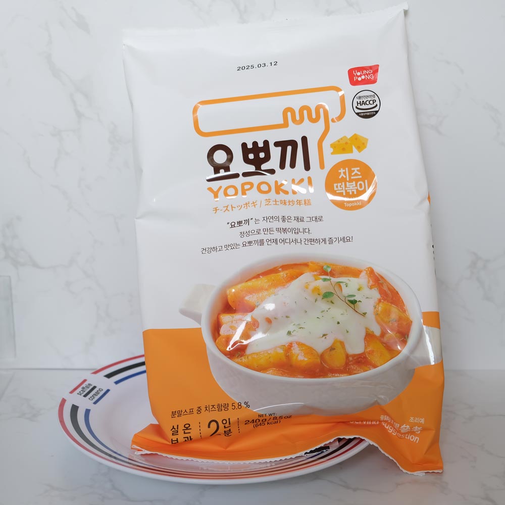 Busta Yopokki Tteokbokki Formaggio Youngpoong con sfondo marmo e piatto di Scaffale Coreano