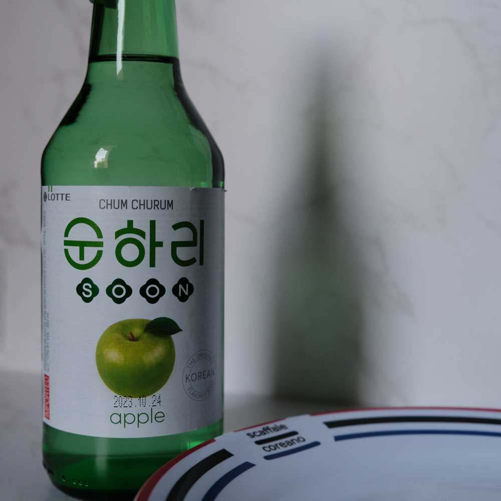 Bottiglia di Soju alla Mela con sfondo marmo e piatto di Scaffale Coreano