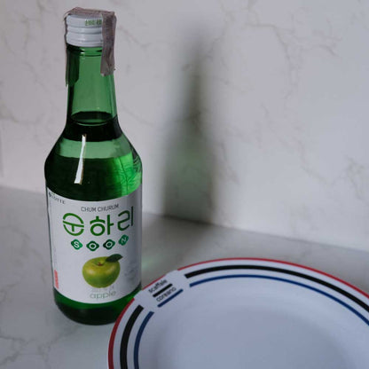 Bottiglia di Soju alla Mela con sfondo marmo e piatto di Scaffale Coreano