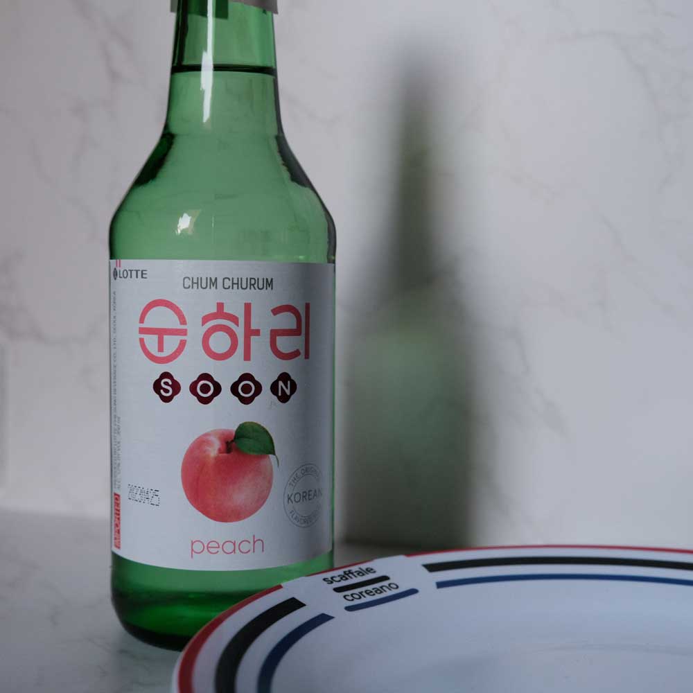 Bottiglia di Soju alla Pesca con sfondo marmo e piatto di Scaffale Coreano