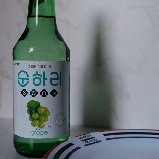 Bottiglia di Soju all' Uva con sfondo marmo e piatto di Scaffale Coreano