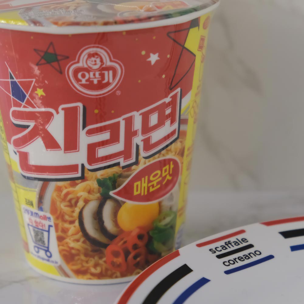 Jin Ramyun Piccante Cup di Ottogi con sfondo marmo e piatto di Scaffale Coreano