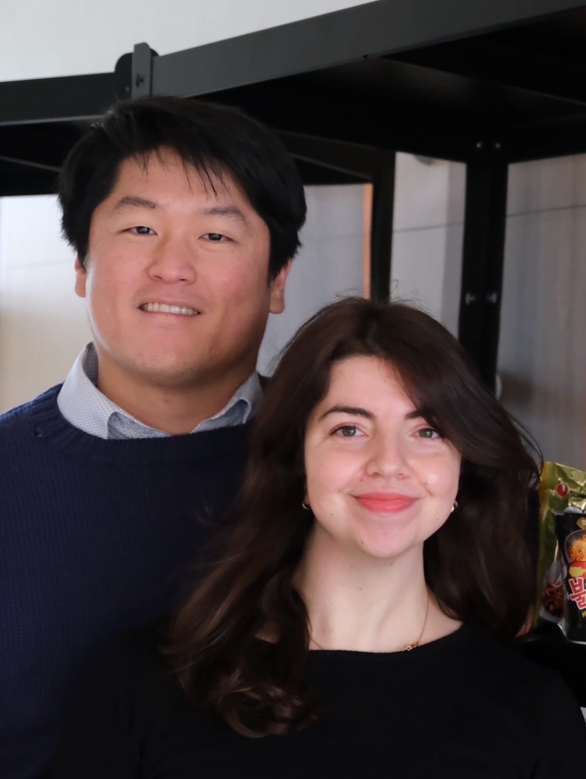Immagine di Francesca e Kyeong-uk proprietari di Scaffale Coreano accanto a scaffali con Ramyun e Kimchi
