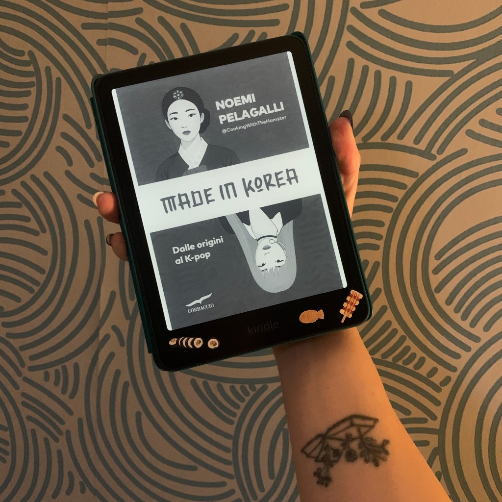 Immagine di una mano che regge un kindle. La copertina del libro è quella di Made in Korea