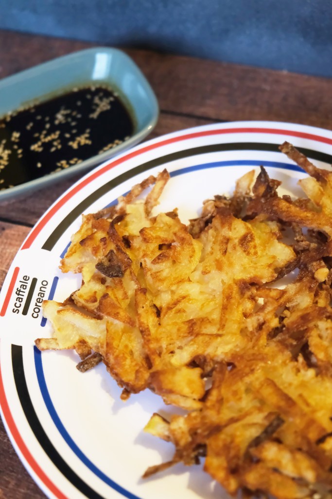 Immagine di un Gamja Jeon Crunchy su un piatto di Scaffale Coreano